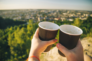 hands with two cups of coffee