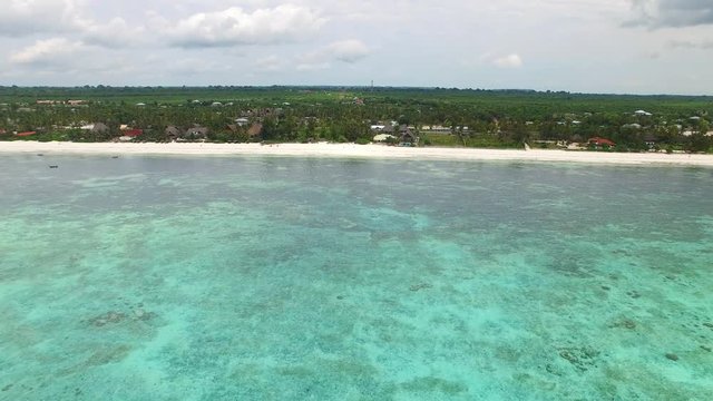 Aerial view of Nungwi, colorful sea water of blue lagoon, north part of Zanzibar, White beach, Palm paradise, Tanzania from above, Africa, Indian Ocean, 4k UHD