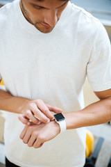 Obraz premium Concentrated young sports man looking at watch