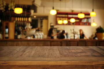 Foto op Plexiglas Afbeelding van houten tafel voor abstracte wazig restaurant lichten achtergrond © tomertu