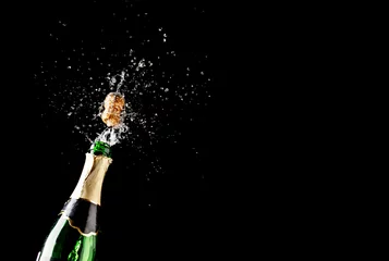 Gordijnen Cork flies out of champagne bottle isolated on black background © Sergey