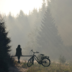 Obraz premium Woman with bicycle resting on a bench