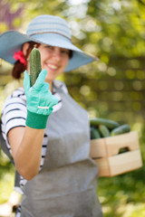 Woman holds cucumber in hand