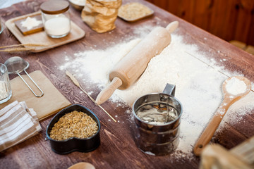 Preparation of the dough. The rolling pin with flour on a wooden table.