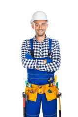 Happy smiling construction worker in uniform and tool belt with crossed arms