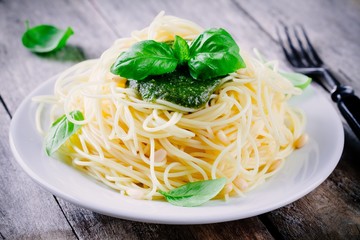 Spaghetti with homemade pesto sauce, olive oil, pine nuts and basil leaves