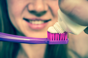 Woman brushing her teeth with toothbrush in the morning