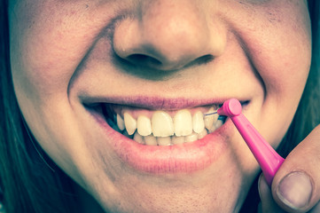 Woman brushing her teeth with interdental brush