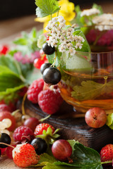 Obraz na płótnie Canvas Hot herbal tea with fresh summer berries and herbs