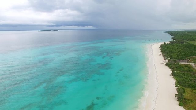 Aerial view of Nungwi, colorful sea water of blue lagoon, north part of Zanzibar, White beach, Palm paradise, Tanzania from above, Africa, Indian Ocean, 4k UHD