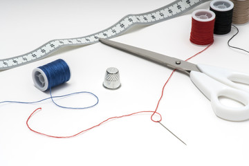 Tailor tools on white table with multiple skeins on both sides