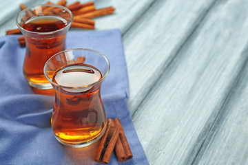 Two glass cups with aromatic hot cinnamon tea on wooden table