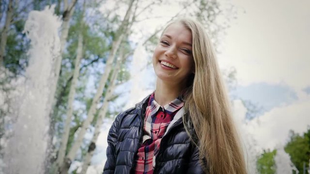 Portrait of happy smiling young blonde woman looking at the camera. Slow motion. HD