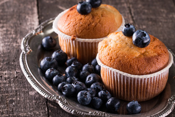 muffin with blueberries on a wooden table. fresh berries and sweet pastries on the board
