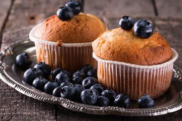 muffin with blueberries on a wooden table. fresh berries and sweet pastries on the board