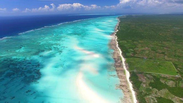 Aerial view of Nungwi, multicolored sea water of blue lagoon, north part of Zanzibar, White beach, Palm paradise, Tanzania from above, Africa, Indian Ocean, 4k UHD