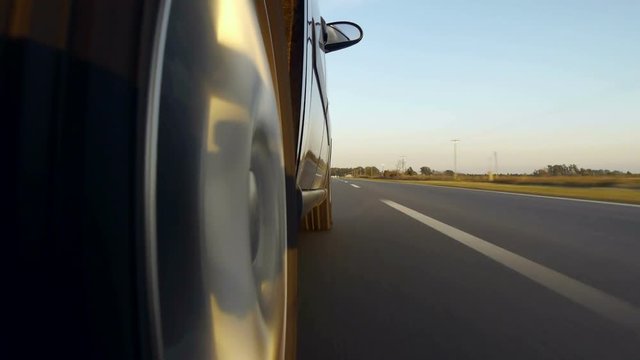 Driving a black / super car on a country road. Wheel spinning POV - Point of View, day country side, sunset, fall / winter. Trees on the side. Fast Speed / time-lapse. Right side wheel / driving UK 