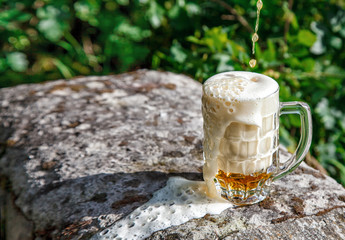 glass mug with beer standing on the big stone