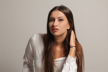 Serious young woman on a gray background