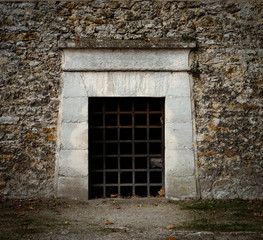 A door with rusty iron bars - like an entrance to a dungeon, tomb or ancient prison