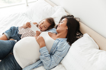 Happy pregnant woman and her little daughter