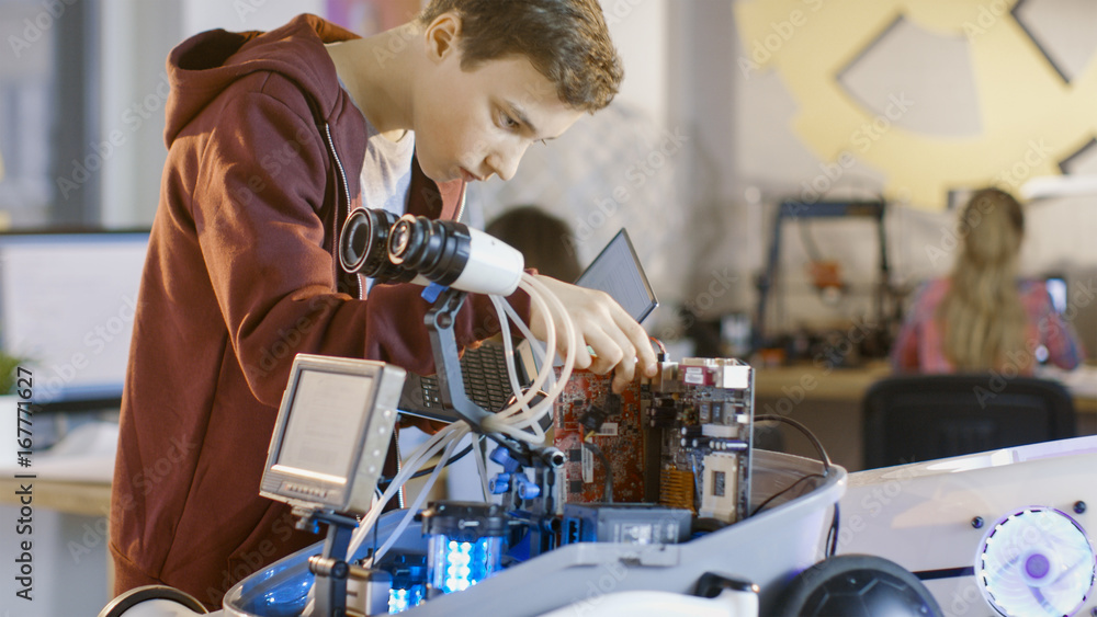 Poster boy works on a fully functional programable robot with bright led lights for his school robotics clu