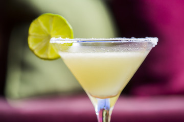 Yellow coctail with lime, margarita cocktail with salty rim