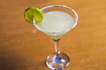 Yellow coctail with lime, margarita cocktail with salty rim