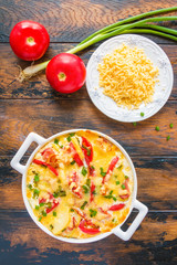 Casserole in Belgian style with smoked bacon, potatoes and cheese. Wooden rustic table, top view.