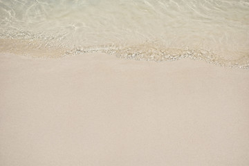 soft wave of crystal clear water on sandy beach for background