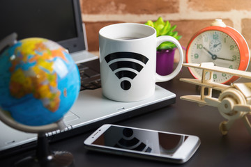 Table of office stuff Business man with Laptop, Wireless mouse, Smart phone, Toy wooden plane and Coffee Cup WIFI symbol.Concept office Business man workplace.