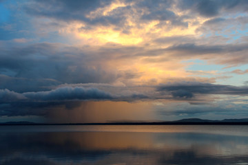 Fototapeta na wymiar Sunset and rain clouds over Orsa lake, Sweden.