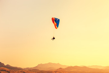 Paragliders fly over the valley.