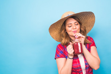 Young sexy woman drinking tasty smoothie on blue background and copy space, vintage outfit, studio lifestyle portrait, dessert