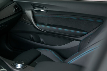 Luxury car interior with leather seats and carbon fibre look trims.
