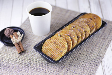Viennese wafers with caramel on a wooden background