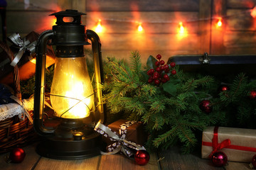 New Year composition of branches of Christmas trees decorated with balls Vintage lamp with burning...