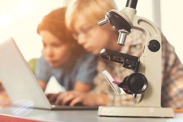 Silhouettes of two boys that looking at screen of computer