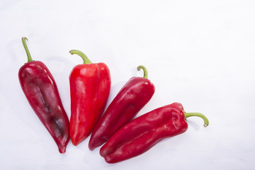 Four red peppers as a vegetable on white background