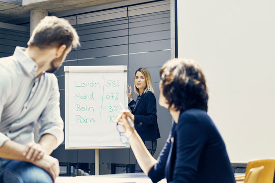Young businesswoman giving international business presentation in office