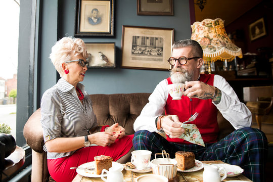 Quirky vintage couple drinking tea in tea room