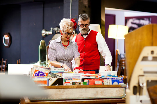 Quirky vintage couple looking at vinyl records in antique and vintage emporium