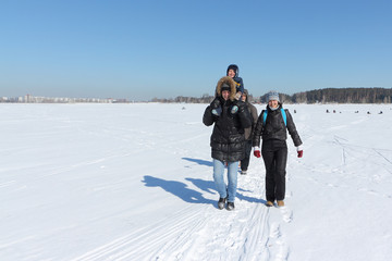 Fototapeta na wymiar Happy family traveling around the snow river in the winter