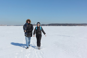 Fototapeta na wymiar Man, woman and the child walking on the snow river in the winter, Siberia, Russia