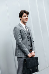 Handsome businessman in suit standing with briefcase