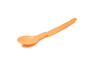 Bright orange plastic baby spoon isolated