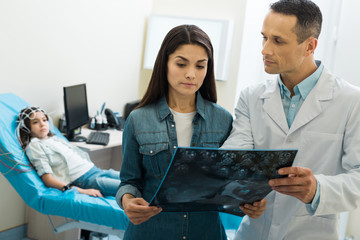 Doctor showing CT scan results to mother of patient