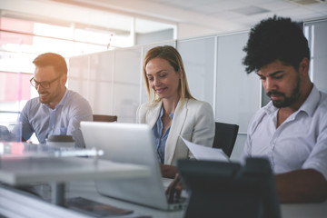 Business people working in office. Business people having coffee break. African man holding document and using laptop.