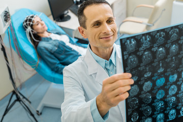 Pleasant doctor being pleased by CT results of his patient - obrazy, fototapety, plakaty