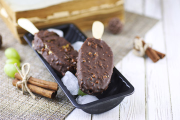 Fototapeta na wymiar Dessert chocolate ice cream with nuts on wooden stick
